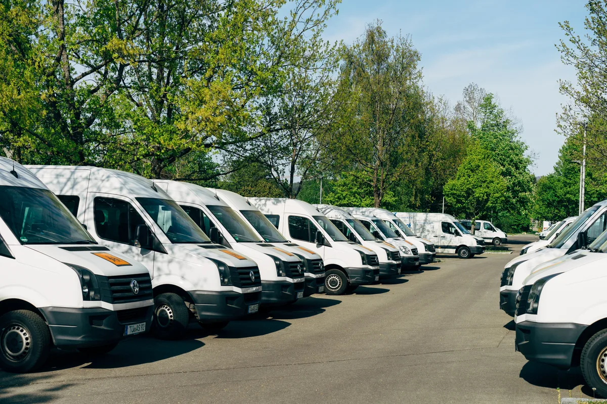 Rows of white commercial work vans parked together